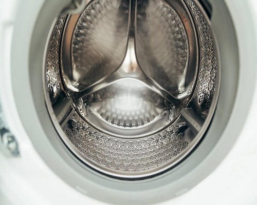 Modern washing machine drum interior being examined during maintenance audit