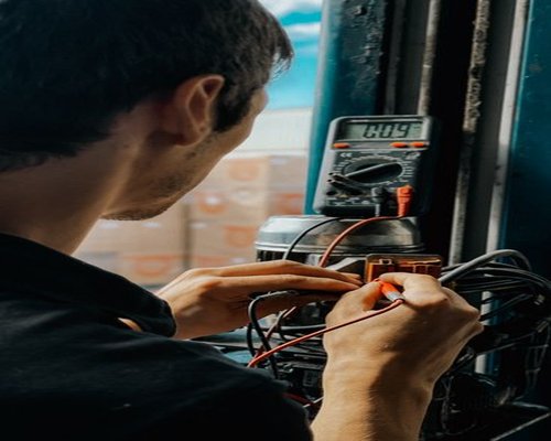 Technician measuring electrical parameters carefully inside a modern utility space